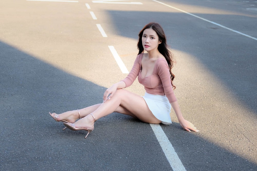 坐在马路中间的长发性感美女户外写真图片
