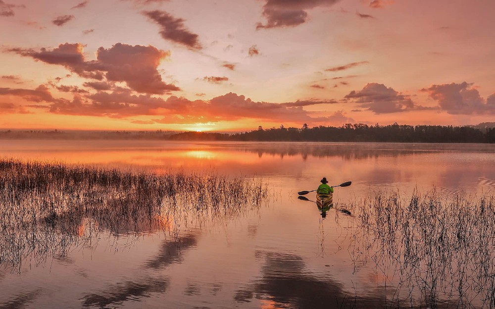 夕阳西下一人一独木舟在平静的湖面荡漾唯美风景壁纸4k